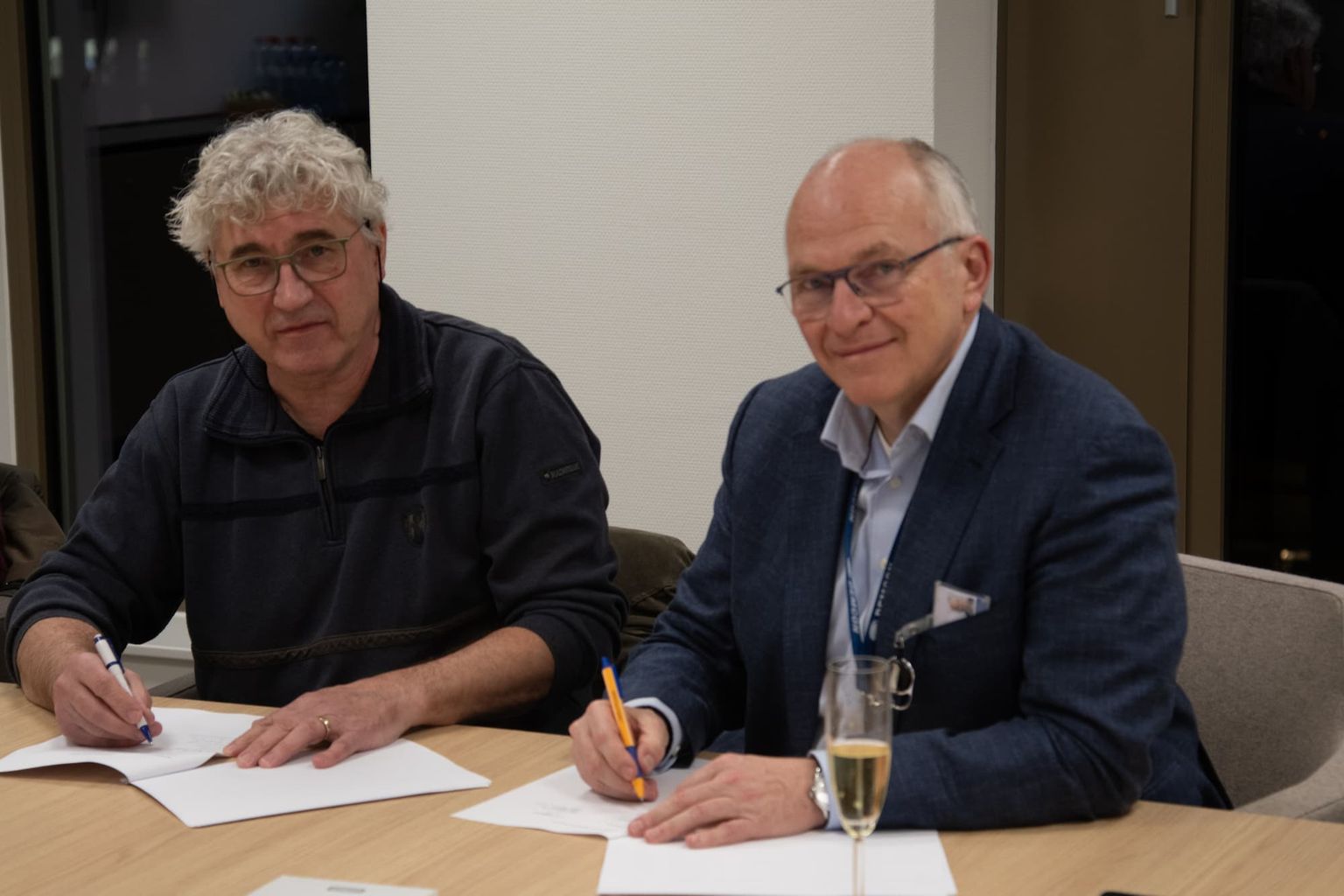 Demcon CEO Dennis Schipper and Leap Development founder Jan ten Thije finalizing the acquisition